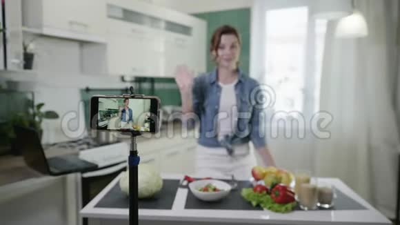 家庭博客现代魅力家庭主妇在手机上写vlog视频谈论健康食品和减肥视频的预览图