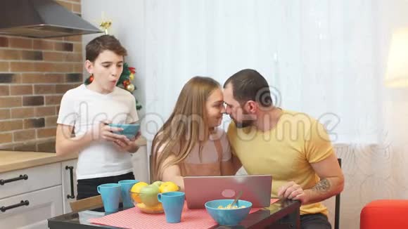 年轻的父母和孩子在厨房吃饭视频的预览图