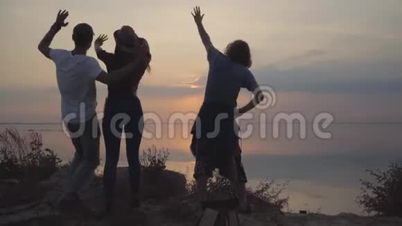 三个年轻的朋友在可怕的日落背景下玩得很开心心情很好视频的预览图