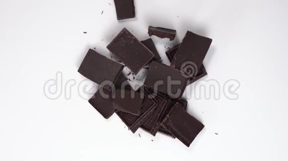 打开的巧克力片的俯视图黑巧克力旋转旋转在白色的桌子上甜点在桌子上视频的预览图