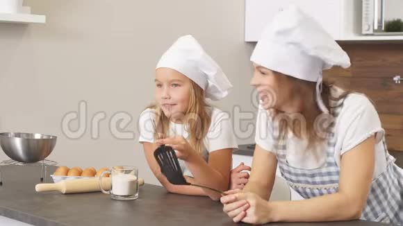 开朗的女人和孩子思考纸杯蛋糕的配方家庭观念视频的预览图
