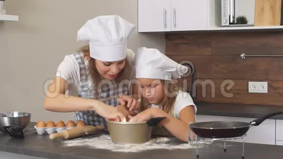 美丽快乐的母女正忙着在厨房里煮面团用面粉窥视篝火视频的预览图