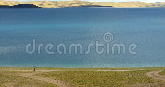 巨大的云层在纳姆索湖上翻滚藏族人在湖边散步视频的预览图