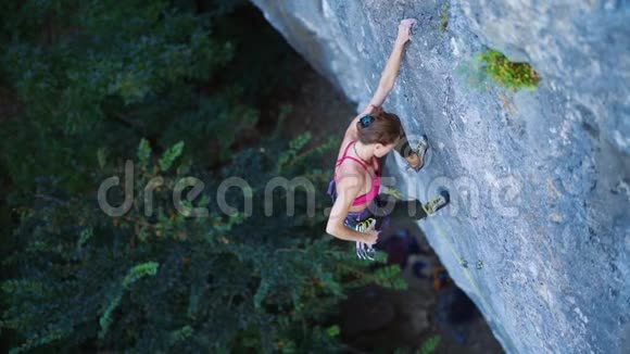 女人在艰难的运动路线上攀爬攀爬者在最后一次速描中完成路线和剪绳视频的预览图