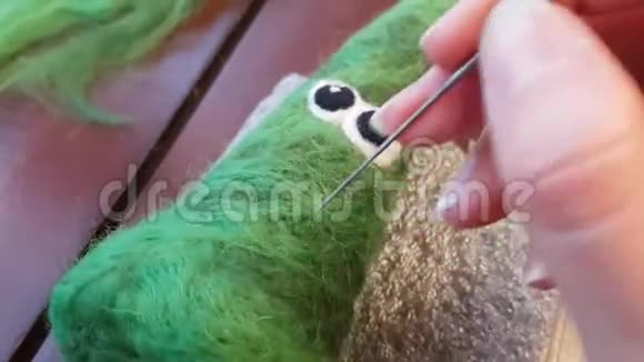 干毡做针线活在桌子上的羊毛上用针工作玩具以有趣的圣诞树的形式产品视频的预览图