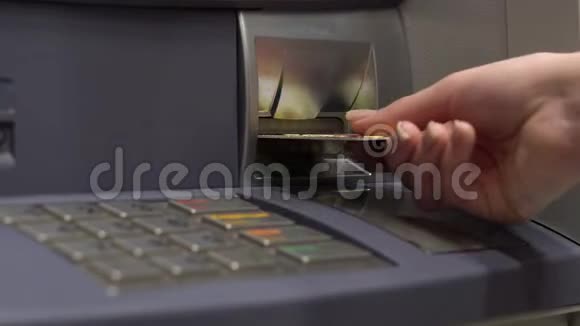 一位年轻妇女把一张银行卡插入ATM机提款机用于现金取款和存款女的手特写视频的预览图