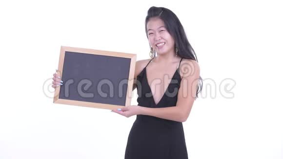 快乐美丽的亚洲女人拿着黑板得到好消息视频的预览图