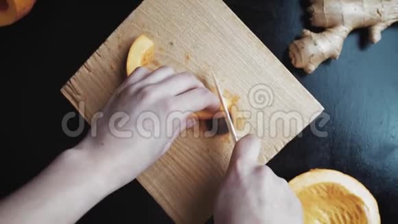 女人在厨房板上切南瓜只有手可见视频的预览图