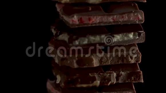 几块不同的巧克力在黑色背景上旋转草莓马斯卡彭坚果牛奶和深色视频的预览图