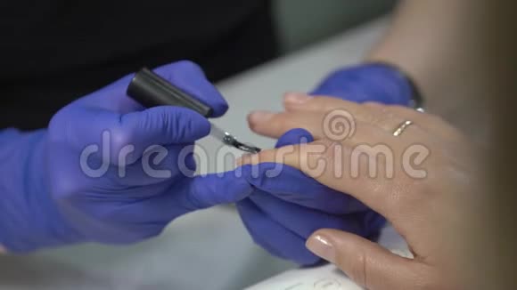 专业修甲师用透明清漆覆盖指甲视频的预览图