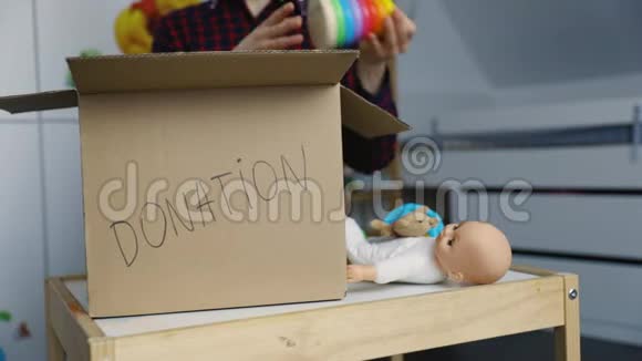 女人把旧玩具放进纸板箱捐赠视频的预览图