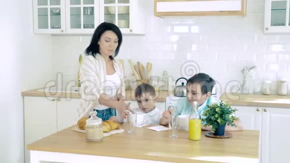 快乐的母亲妈妈为她的儿子做早餐视频的预览图