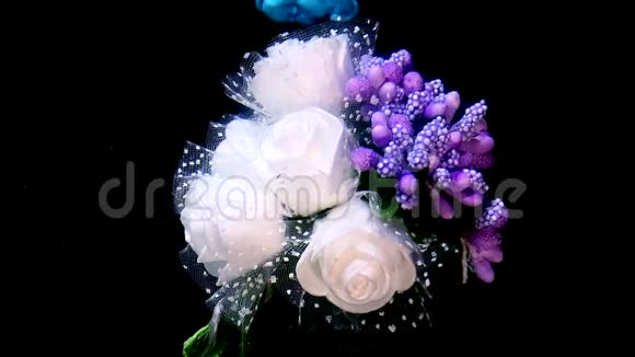 喜庆的婚礼花束白玫瑰和丁香花蓝色和白色水彩墨水在水中的黑色背景上视频的预览图