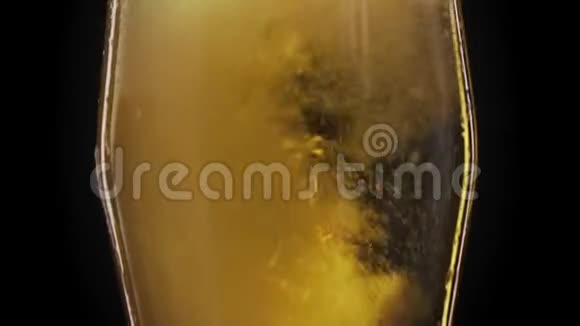 黑色背景下的啤酒杯中冒出细泡一杯啤酒上面有泡沫视频的预览图