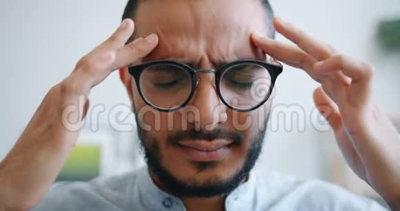不高兴的阿拉伯男人头痛摸头按摩太阳穴视频的预览图