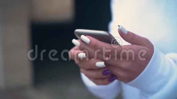 女人的手握着一部手机紧紧地抱着这个女孩用智能手机网上购物视频的预览图