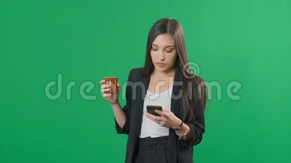 漂亮的欧洲女商人西装革履在彩色绿色屏幕背景上使用智能手机视频的预览图
