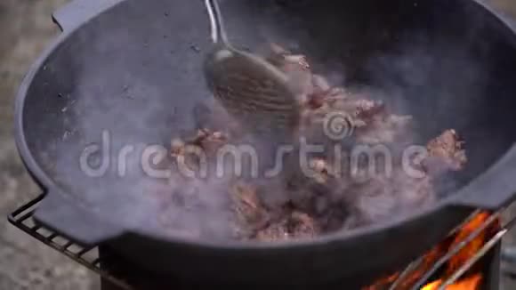 那人把肉放在锅里放在明火上视频的预览图