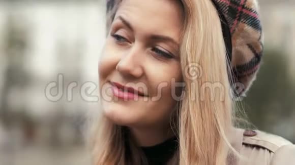 时尚的巴黎女商人穿着贝雷帽和米色风衣害羞地对着镜头微笑肖像画视频的预览图