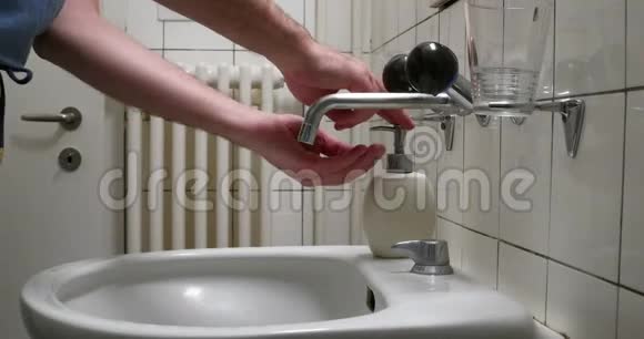 白色男性洗手用液体肥皂在浴室洗手池侧视无脸流水视频的预览图