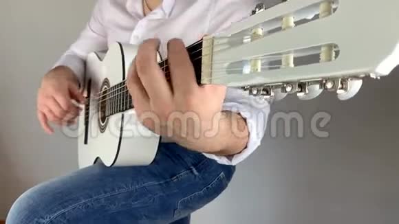 穿白衬衫的男人在家弹六弦古典吉他概念艺术视频的预览图