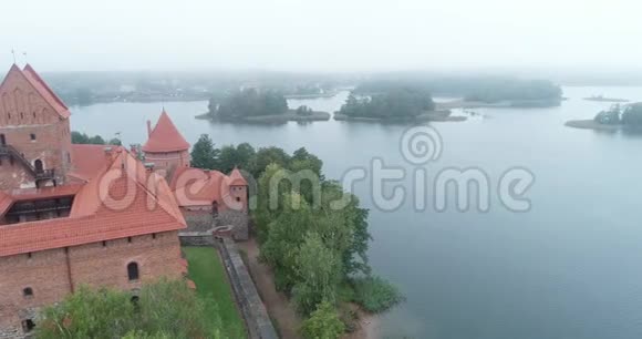 立陶宛特拉凯中世纪哥特式岛屿城堡位于加尔维湖和城镇的背景夏季以上的空中飞行视频的预览图