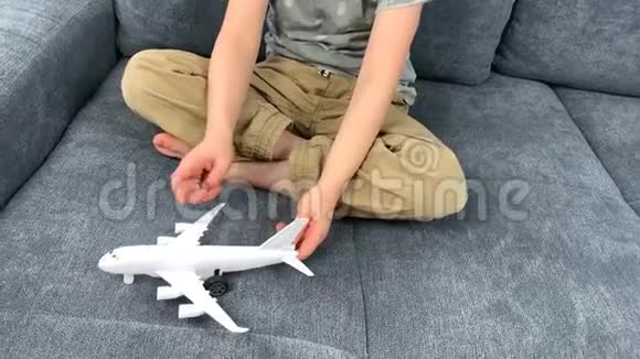 戴黑眼镜的孩子玩白色飞机玩具飞行概念旅行视频的预览图