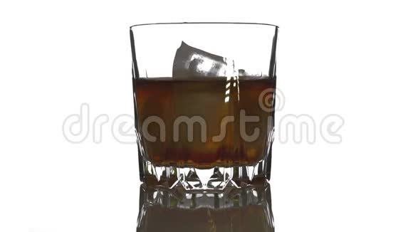 冰块掉下来融化在一杯威士忌里在白色背景下用威士忌旋转冰块视频的预览图
