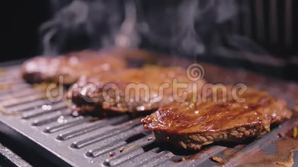 美味多汁的肉排在烤架上烹饪电烤炉上的优质牛肉迷迭香黑胡椒盐慢慢视频的预览图