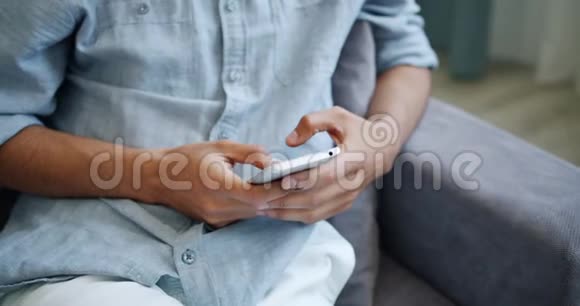 家庭室内使用智能手机触摸屏幕特写男性手视频的预览图