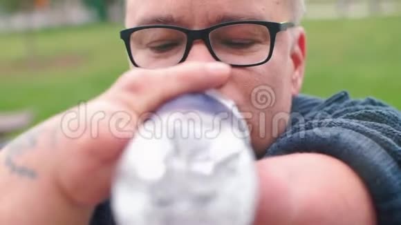 残疾人的特写镜头从瓶子里喝水视频的预览图