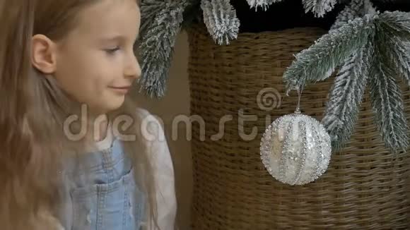 小女孩正在帮忙装饰圣诞树手里拿着一些圣诞银宝宝快乐的童年视频的预览图