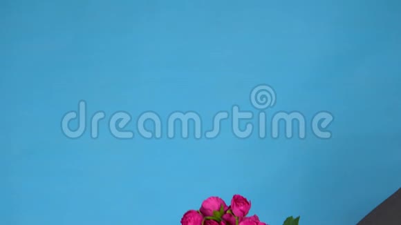 塞博格商人穿着西装带着一束玫瑰灰色的机械手在蓝色的特写镜头上捧着一束鲜花视频的预览图