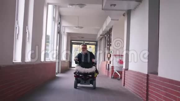 一个坐轮椅的人沿着一条长长的走廊骑着视频的预览图