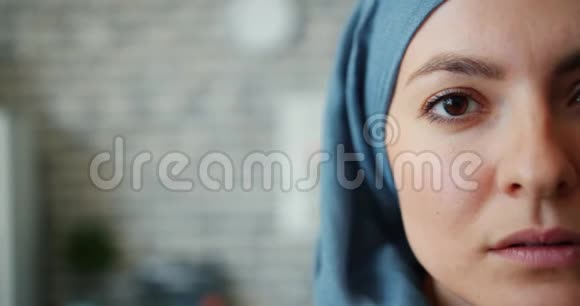 砖墙背景上穆斯林妇女半面头巾特写肖像视频的预览图