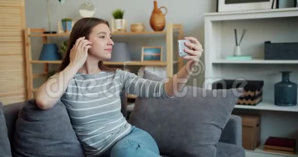 慢动作美女自拍与智能手机触摸头发在家视频的预览图