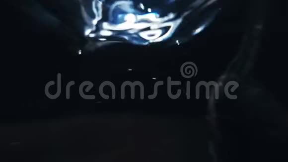关闭调羹搅拌水的宏观黑色背景下液体缓慢运动中的气泡视频的预览图