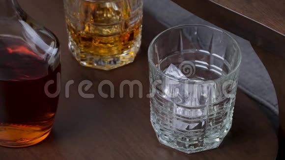 金色威士忌或波旁威士忌倒入玻璃干邑或朗姆酒在玻璃中缓慢流动视频的预览图