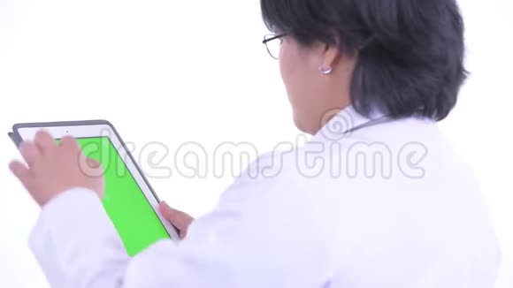 使用数码平板电脑观看快乐超重的亚洲女医生的近距离后视镜视频的预览图