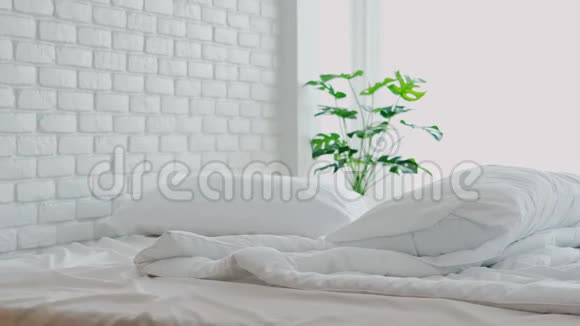 铺有白色枕头和毛毯的床卧室里有自然光线视频的预览图