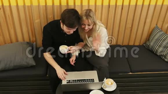 快乐的一对夫妇在餐馆里用笔记本电脑开在线会议视频的预览图