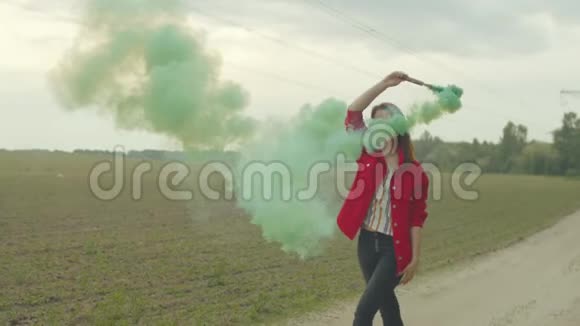 女人在彩色烟雾中旋转走在乡村的道路上视频的预览图