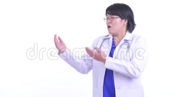 超重的亚洲女医生一边说话一边看东西视频的预览图