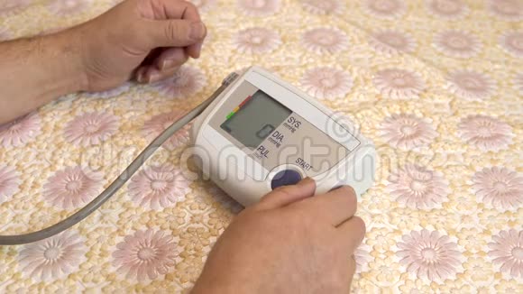 男人用一个装置来测量心脏压力一名男子按下测量压力使用一个吨计特写视频的预览图