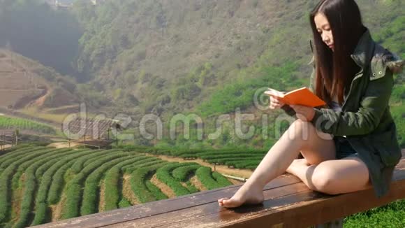 4K度假期间亚洲旅游期间在茶园看书的休闲亚洲妇女视频的预览图