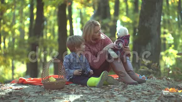 母亲和孩子儿子在秋天的大自然中玩得很开心年轻父母和孩子们在野餐和放松视频的预览图