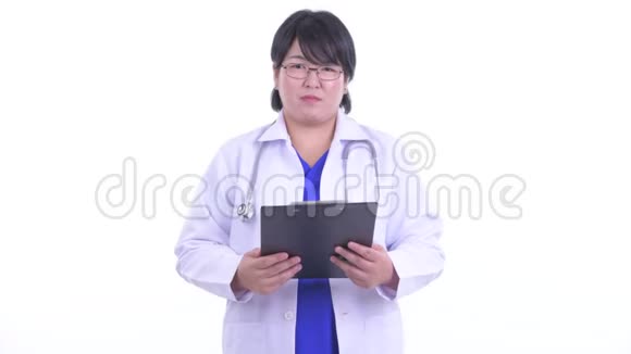 快乐超重的亚洲女医生拿着夹子说话视频的预览图
