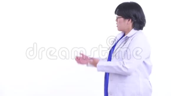 穿着超重的亚洲女医生一边对着后面说话视频的预览图