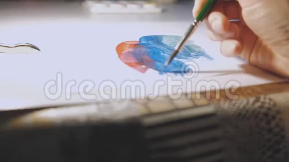 一个色彩的水彩调色板和一个女人用画笔绘制一幅抽象的画视频的预览图