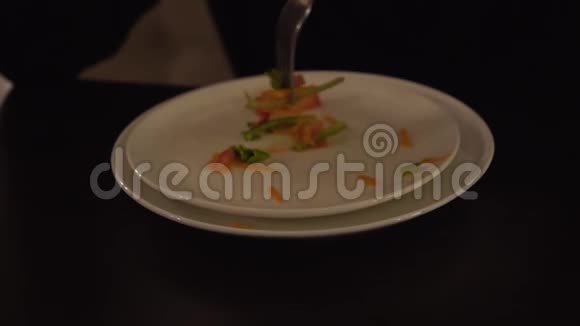一只雄性手用叉子从盘子里收集剩下的食物盘子里剩下的蔬菜沙拉视频的预览图